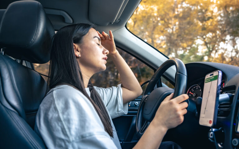 Driver feeling uncomfortable due to a faulty car air conditioner in Brisbane heat.